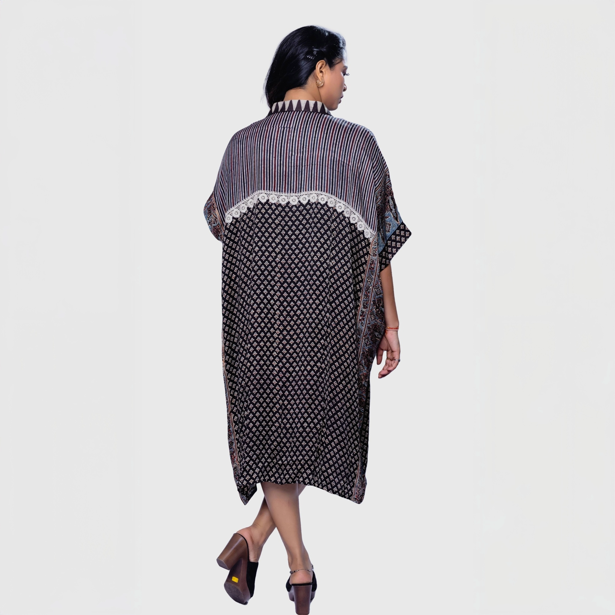 Woman wearing Natasha Mehta ajrakh mosaic cape kaftan with mixed patterns and mid-length design
