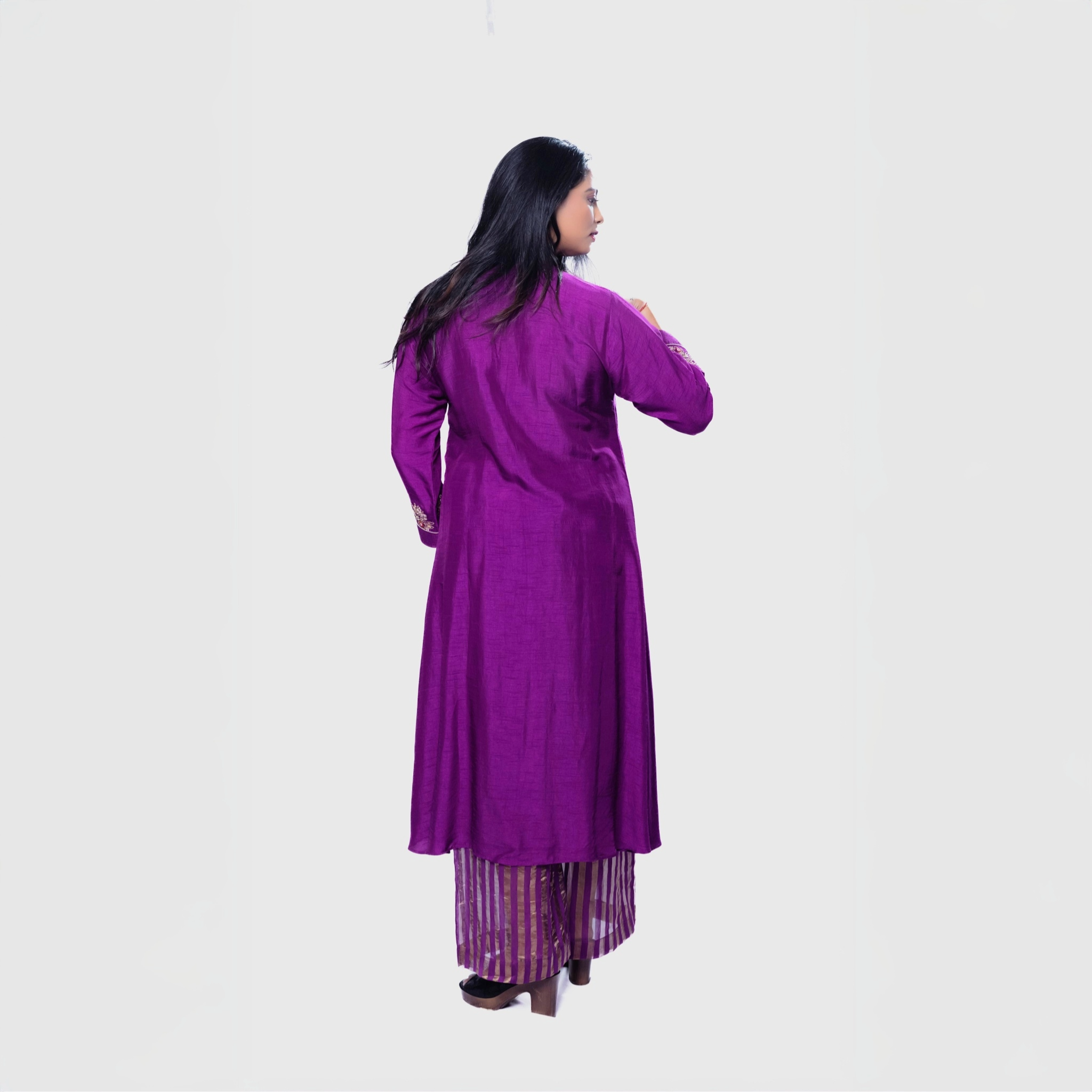 Back view of woman wearing purple Amara embroidered kurta set with striped palazzo pants