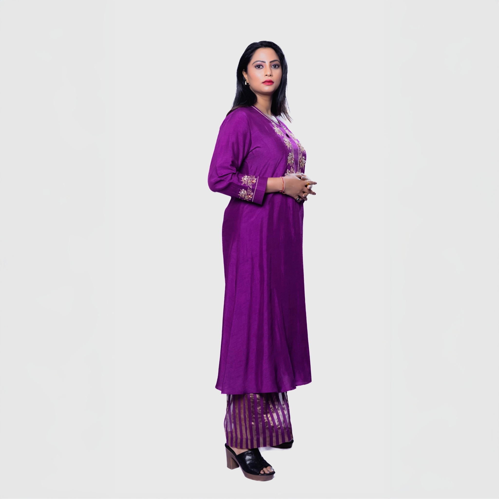 Woman wearing purple Amara embroidered kurta set with matching pants and black heels