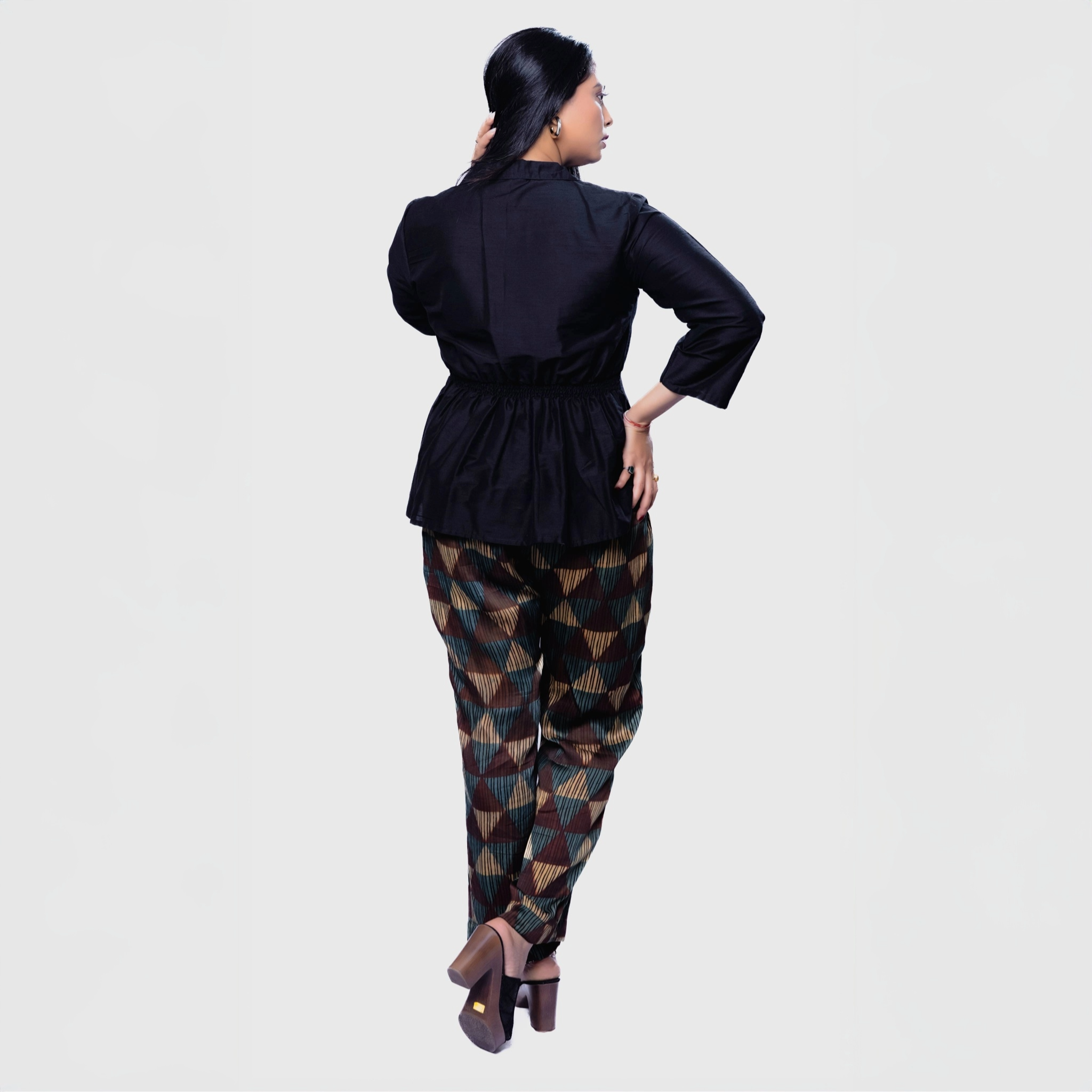 Stylish black collared top and pants set featuring a cinched waist and patterned trousers