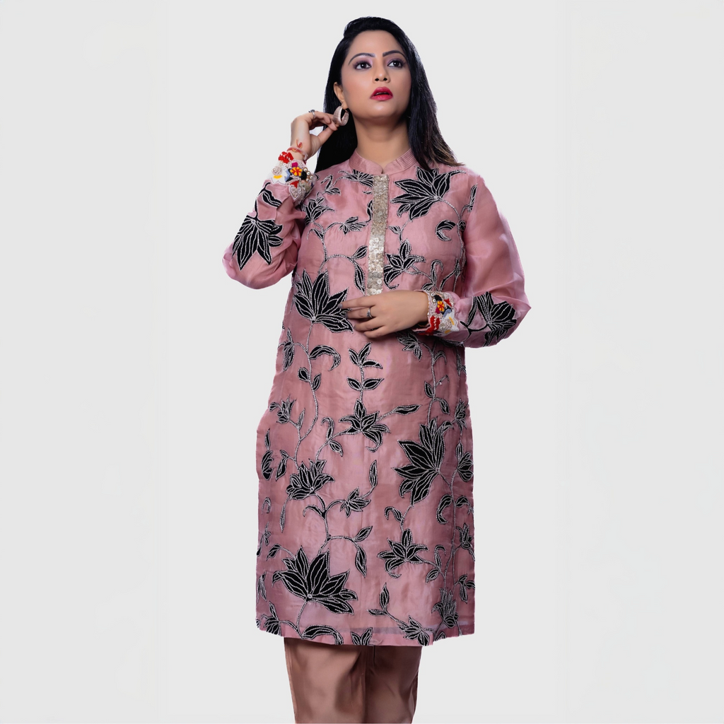 Model wearing a blush floral embroidered kurta set with intricate black leaf designs and vibrant sleeves