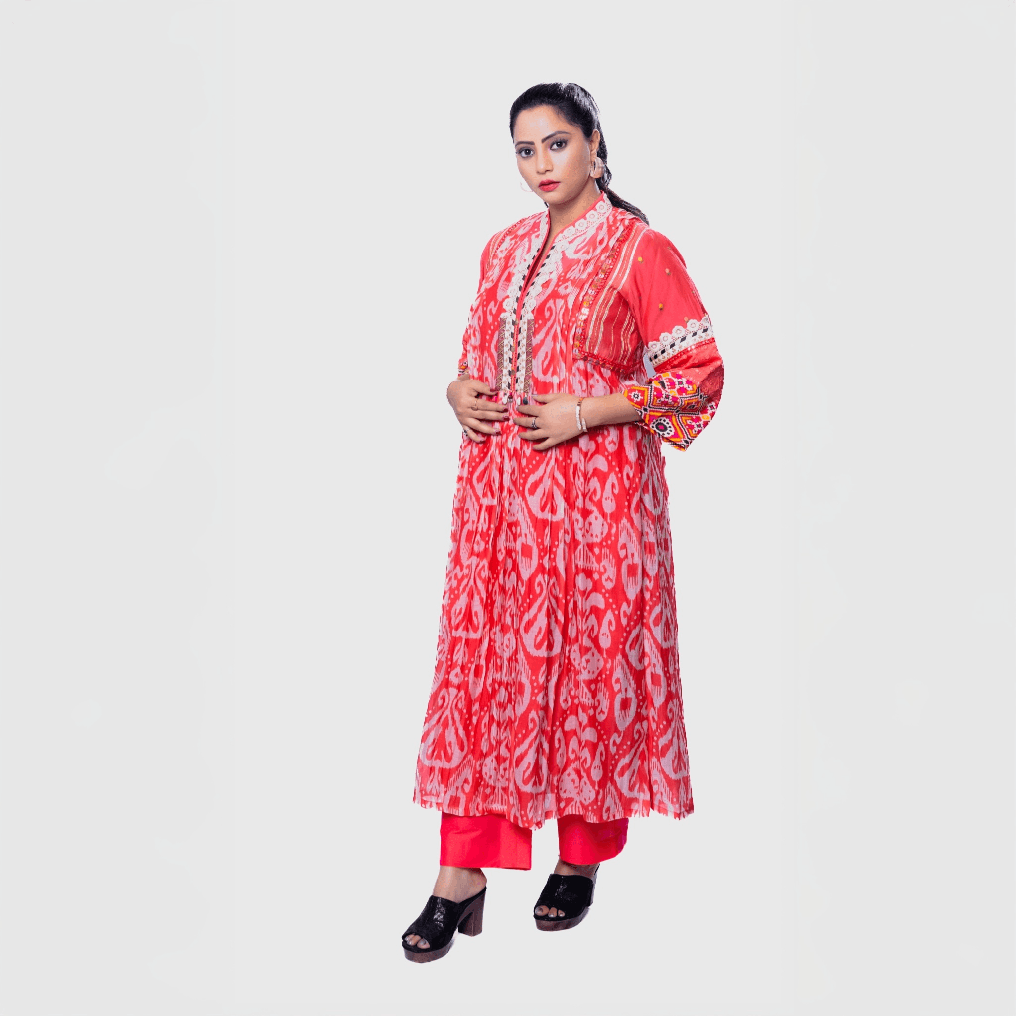 Vibrant embroidered kurta set for women in coral with intricate patterns, ideal for festive occasions.