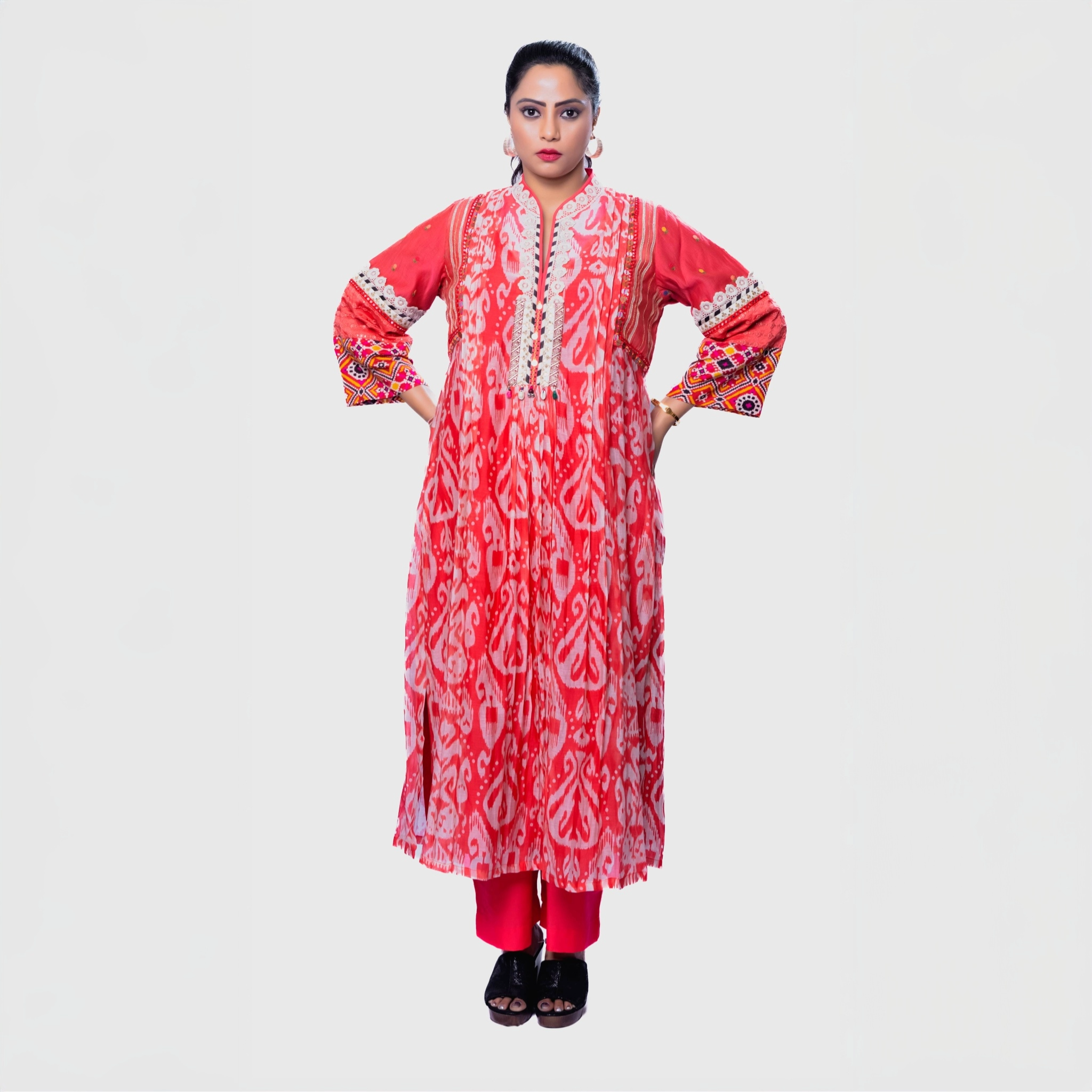 Embroidered kurta set for women in vibrant coral with intricate floral patterns and embellished sleeves, perfect for festive occasions.