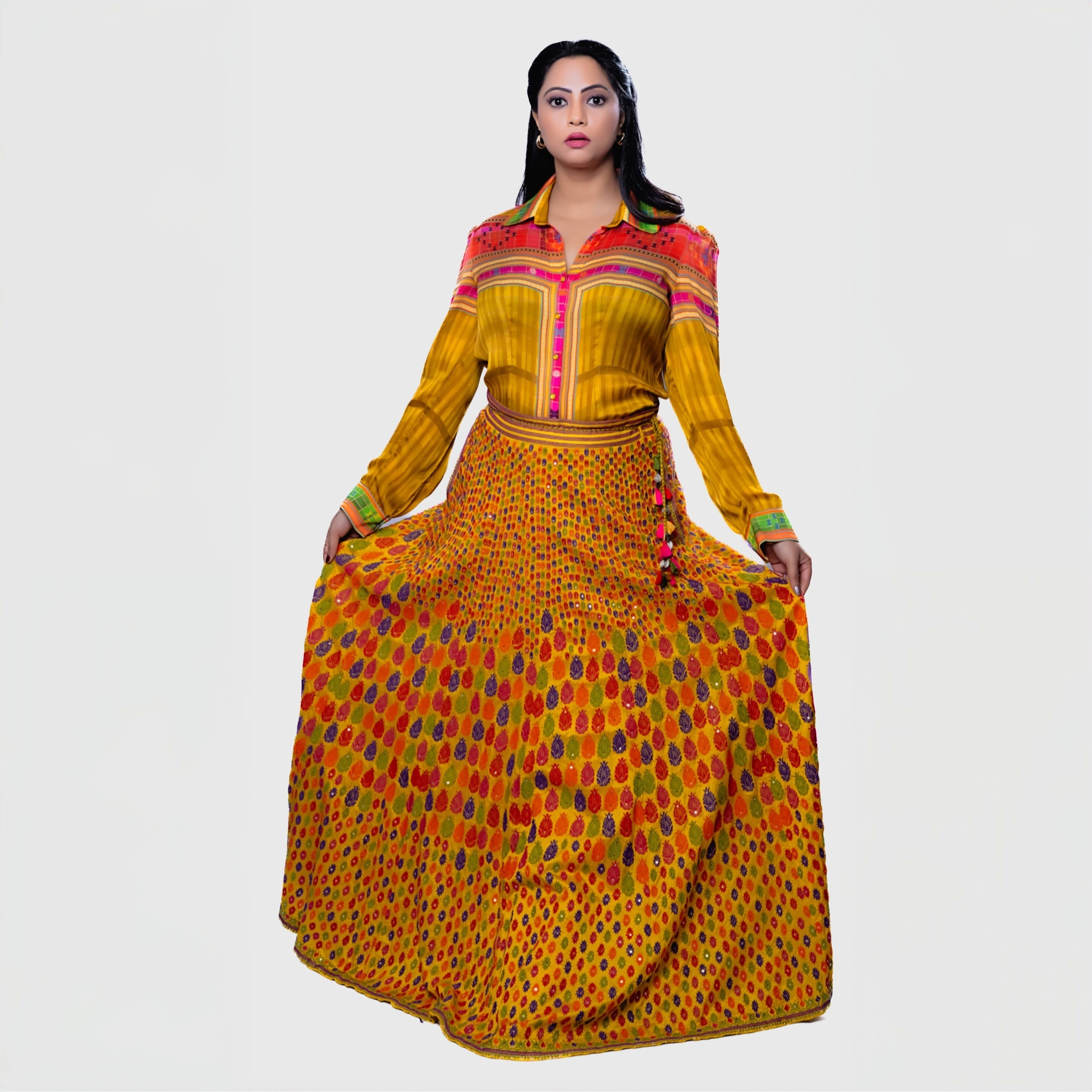 Colorful leheriya ensemble for parties featuring a vibrant yellow top with pink accents and a long skirt with a dotted pattern