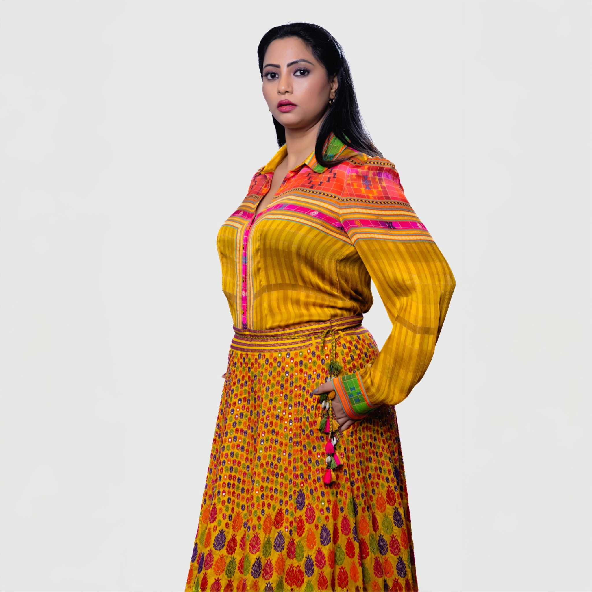 Colorful leheriya ensemble for parties featuring a vibrant shirt and long skirt in yellow and orange tones