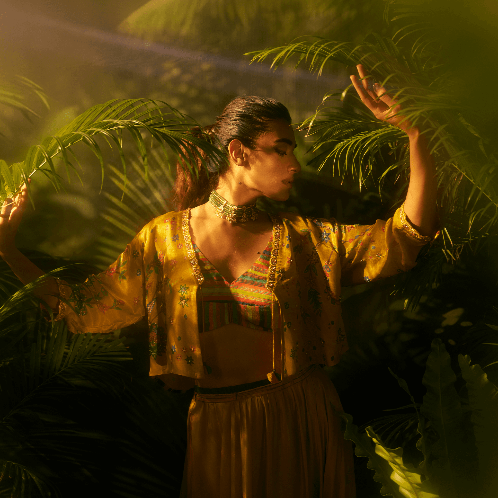 Stunning designer ghaghra choli with jacket in vibrant colors showcased among lush greenery