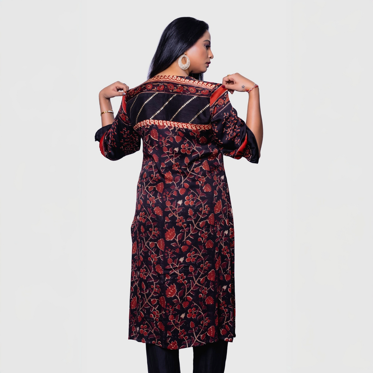 Back view of a woman wearing a designer rust kurta for women with floral and striped patterns