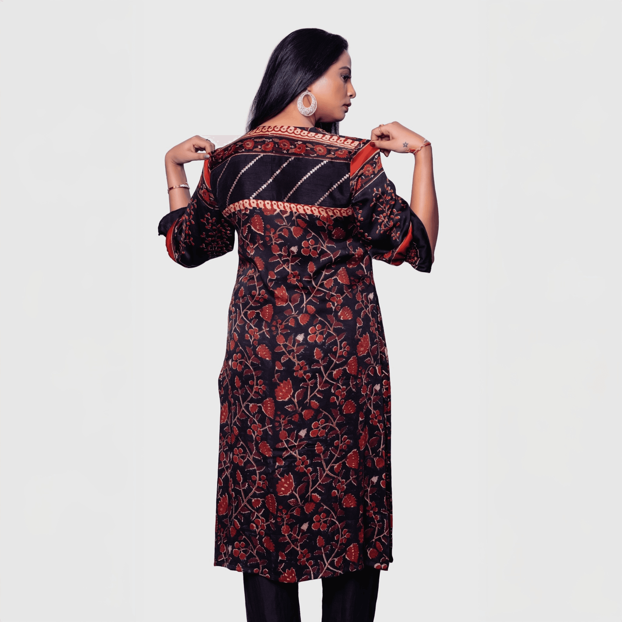 Back view of a woman wearing a designer rust kurta for women with floral and striped patterns