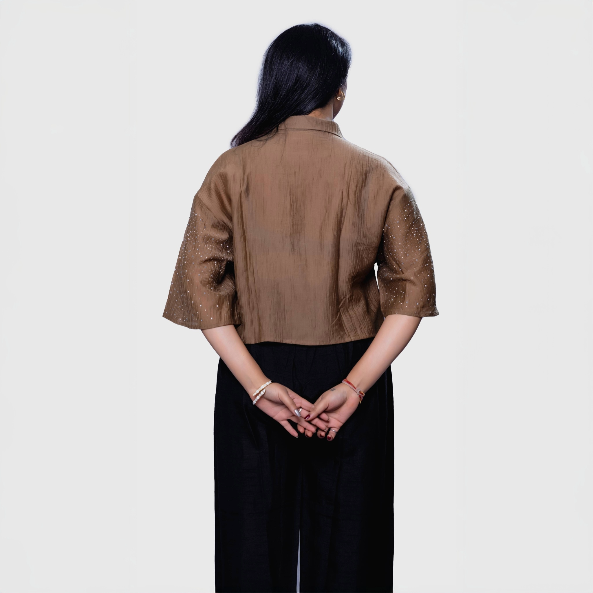 Back view of designer shimmering blouse Dubai brown sequin top with black pants outfit