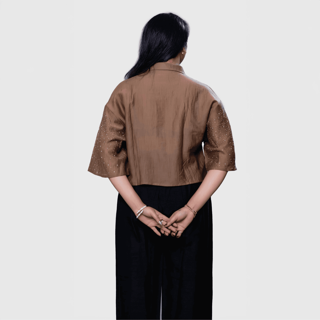 Back view of a designer shimmering blouse Dubai paired with stylish black pants