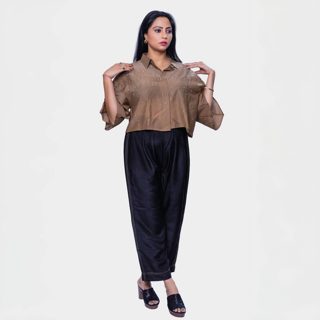 Designer shimmering blouse Dubai in golden color with sparkling sequences, paired with black wide-leg pants