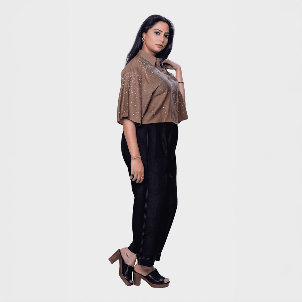 Designer shimmering blouse Dubai in bronze with sequins paired with black pants for elegant occasions