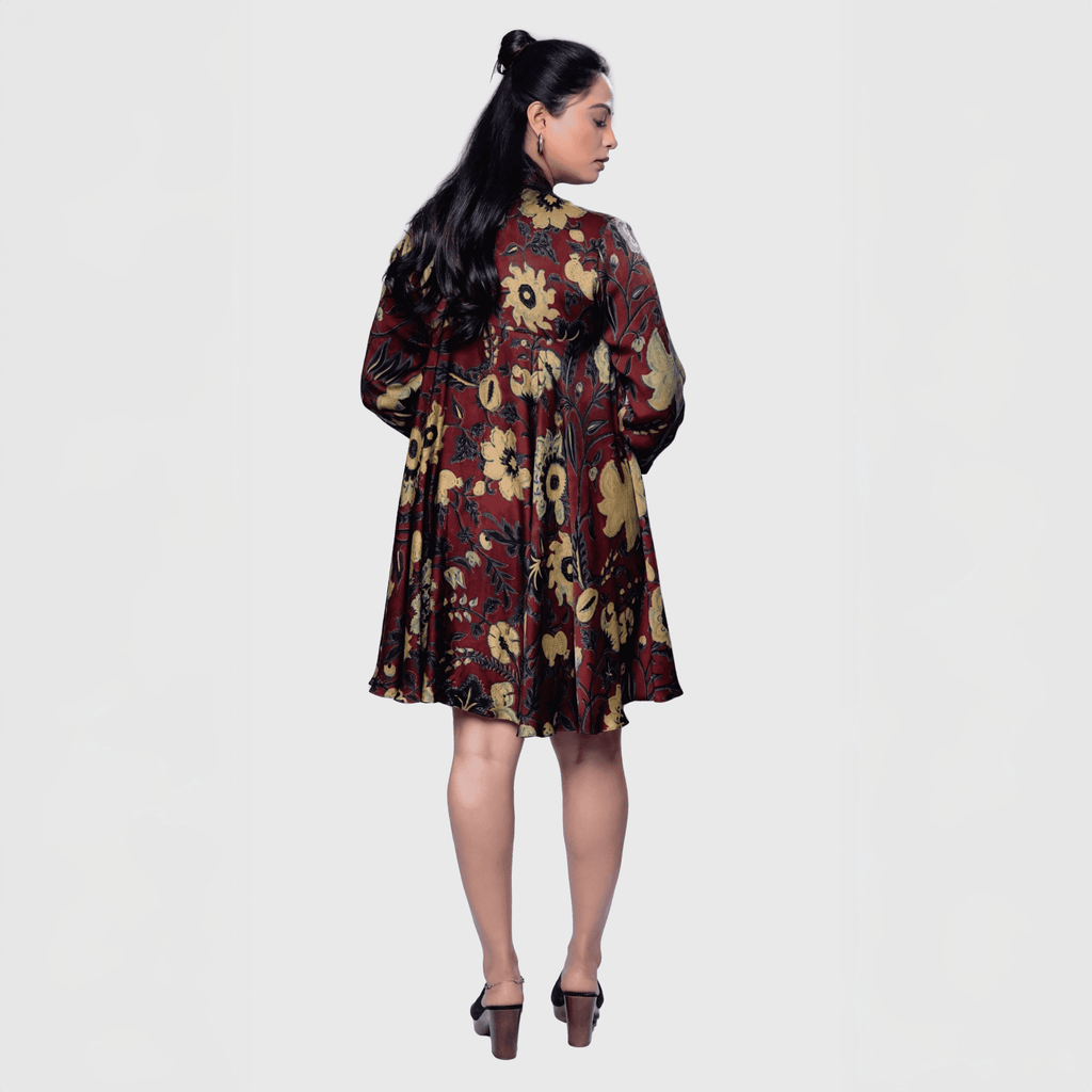 Woman wearing an elegant floral evening dress with a vibrant pattern and flowing design