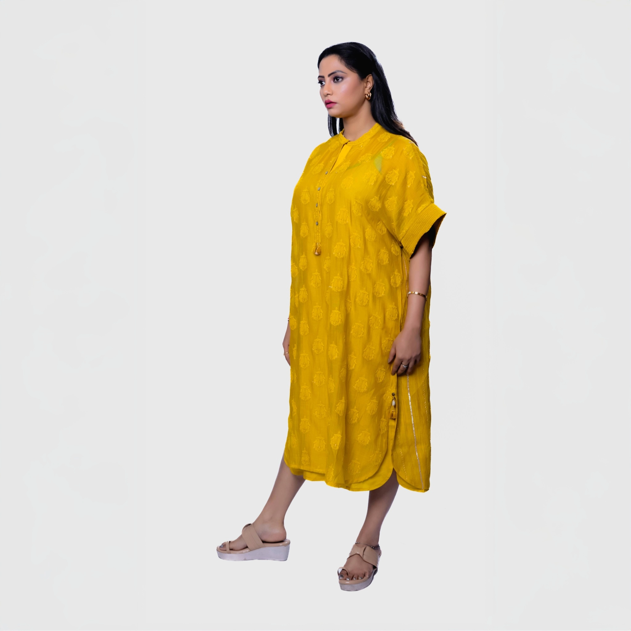 Yellow knee length kurta dress with side slit tassel buttons and short sleeves modeled for fusion fashion kurtas online