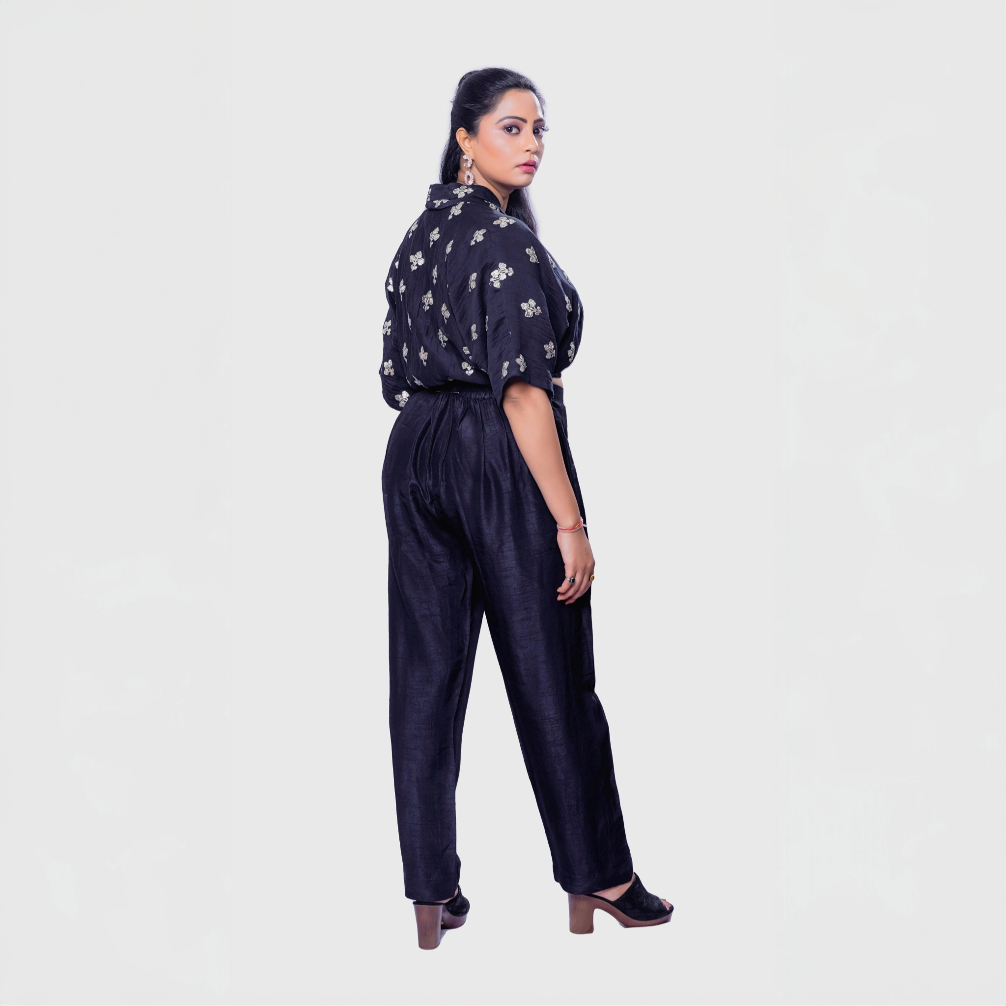 Woman wearing a handcrafted black co-ord outfit with embroidery featuring a black top and pants