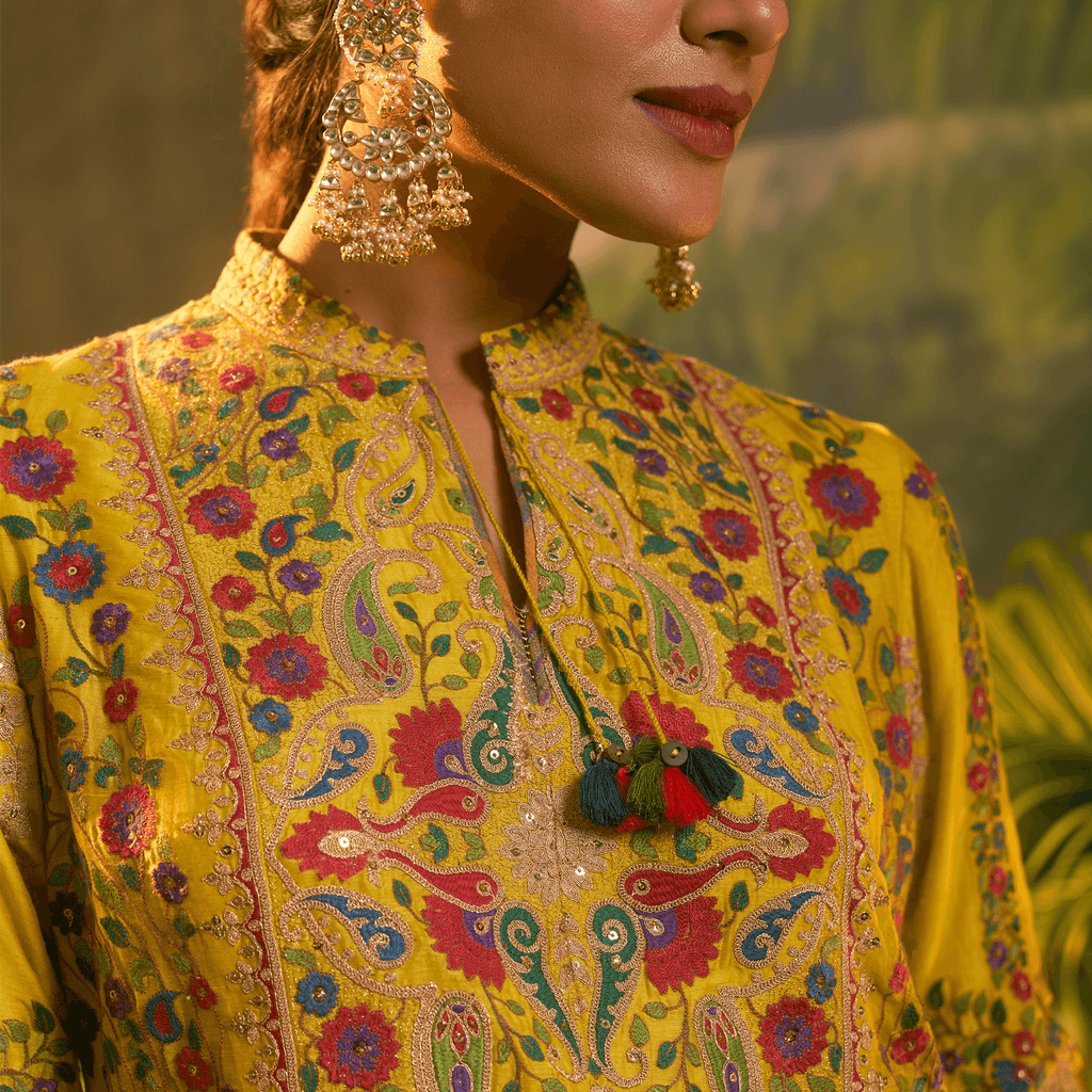 Mustard yellow embroidered kurta set featuring intricate floral designs and stylish tassels