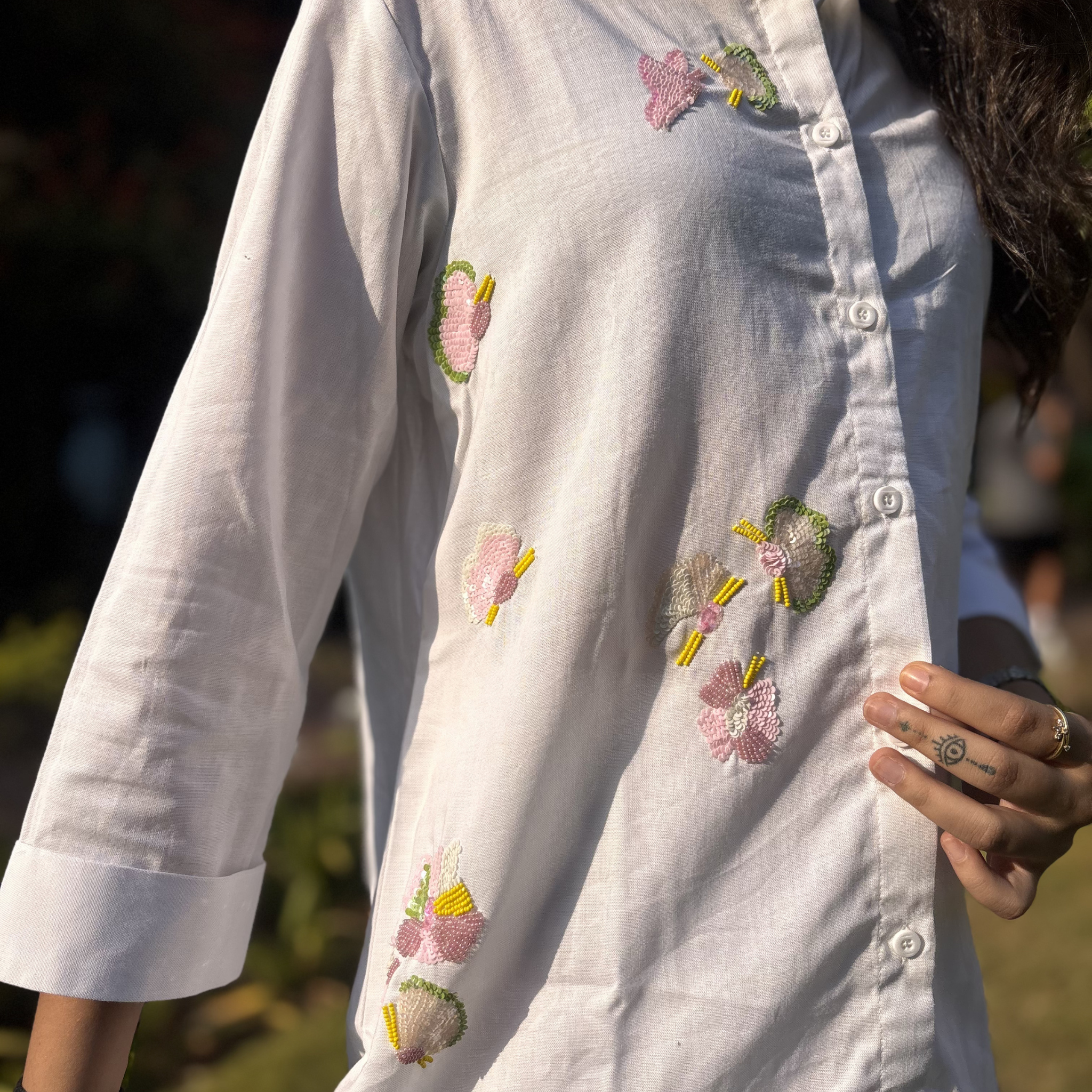 White button-up shirt with colorful floral embroidery, perfect for women's clothing in casual or Dubai settings.
