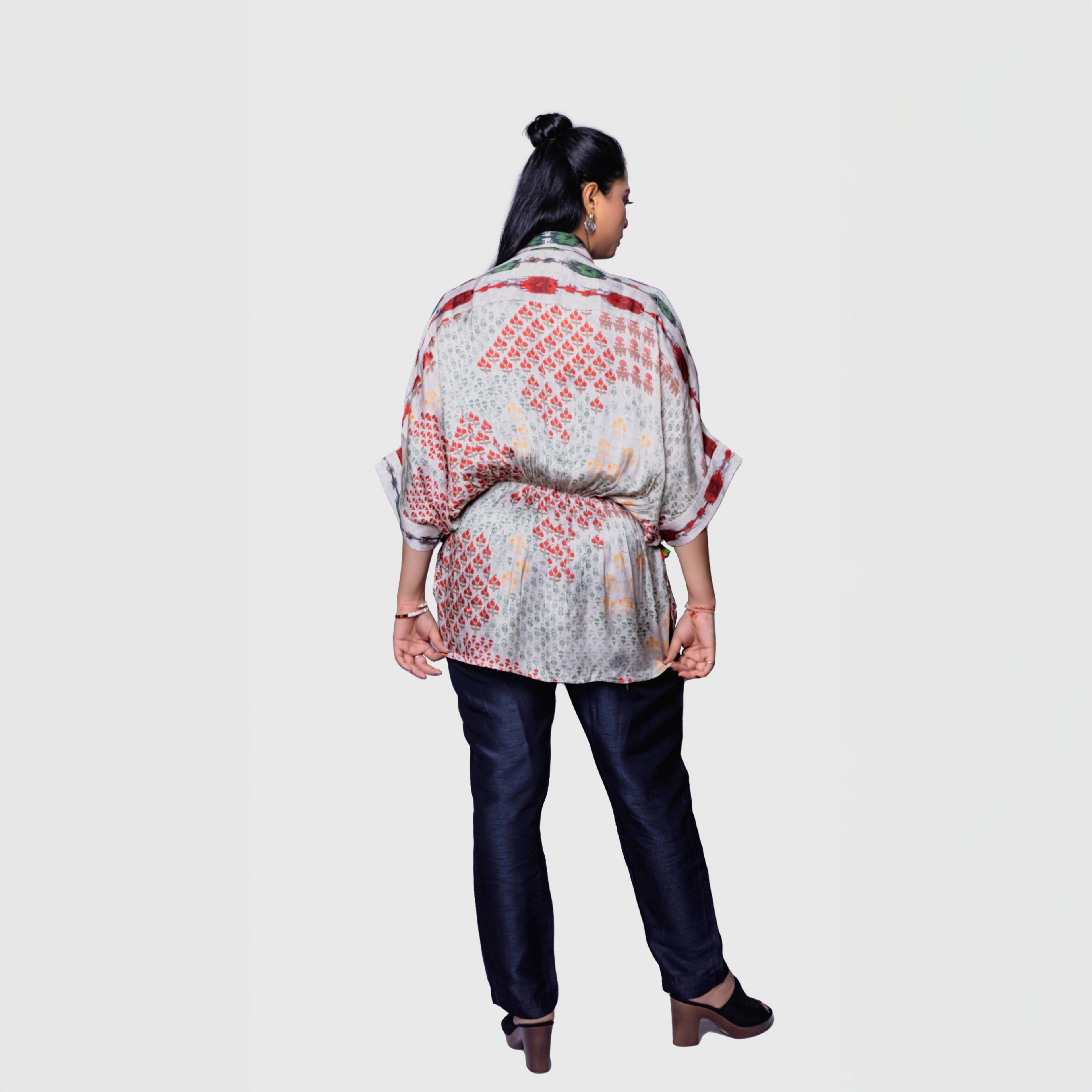 Back view of model wearing patterned belted designer kaftan top for women paired with dark pants and heels
