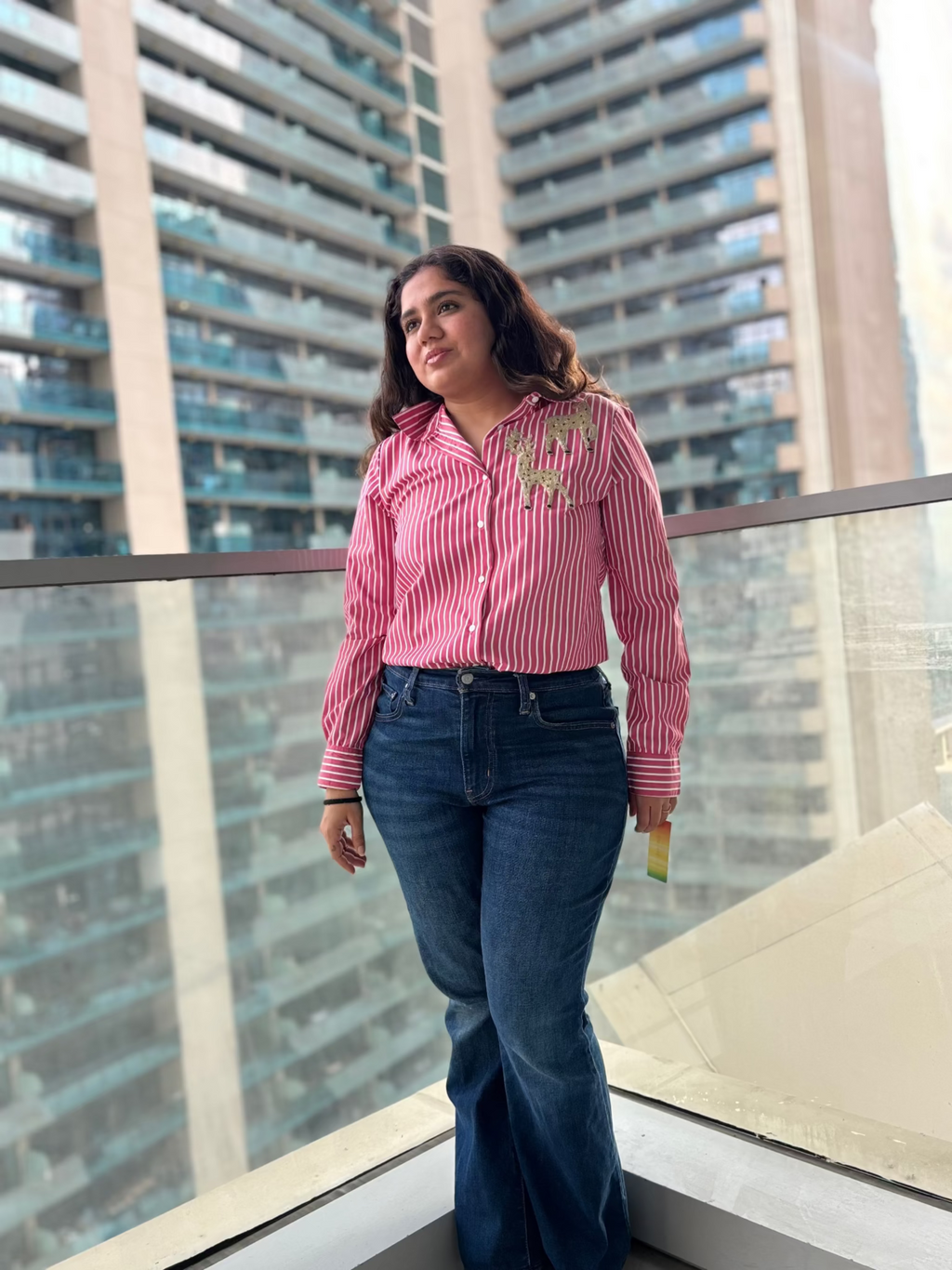 Stylish pink striped sequin top for parties paired with denim jeans, perfect for a vibrant look