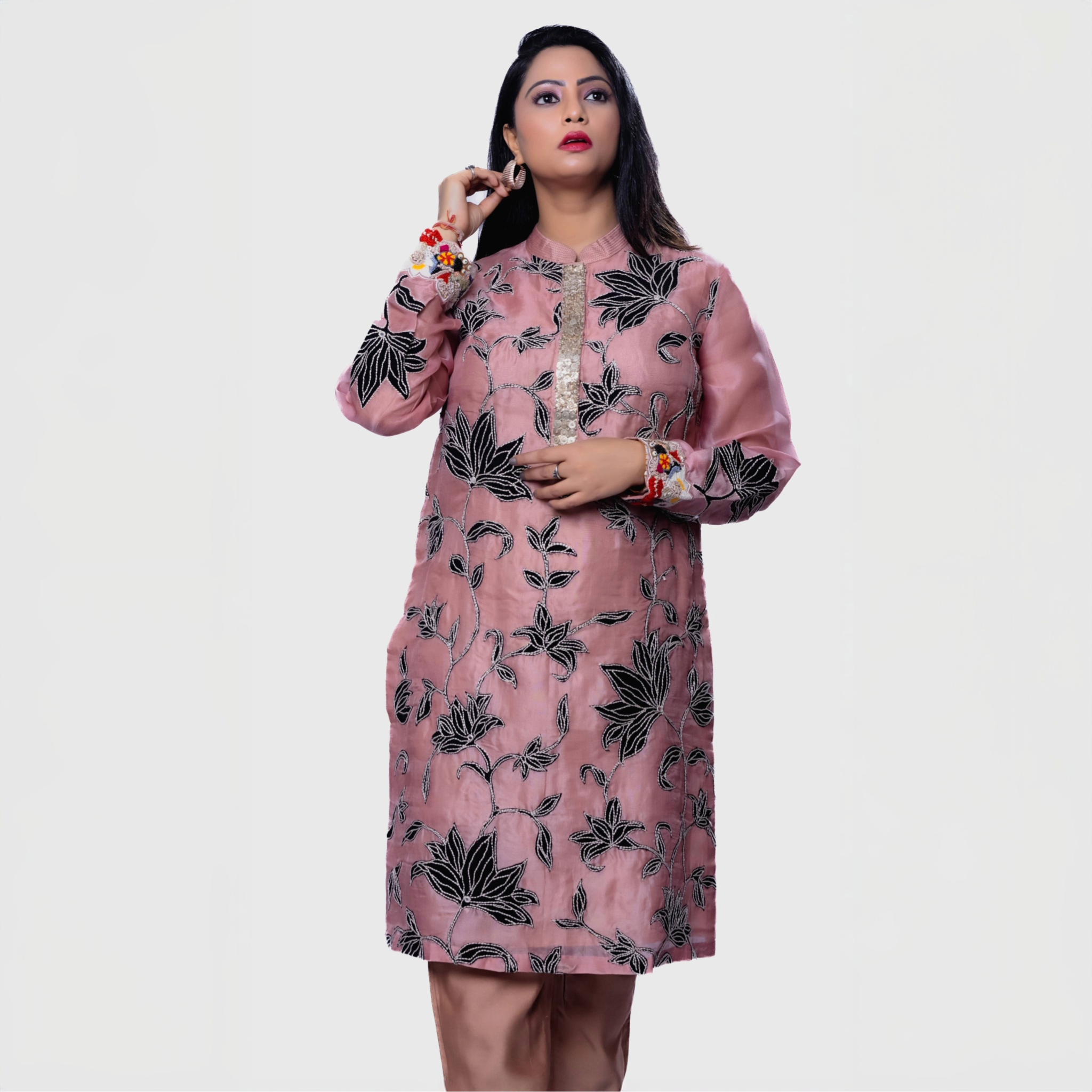 Blush floral embroidered kurta set with black flower patterns worn by woman in stylish pose