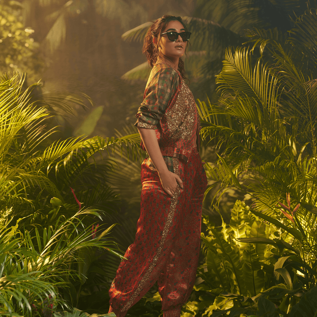 Trendy women's statement bomber jacket India worn in a lush tropical setting with stylish sunglasses